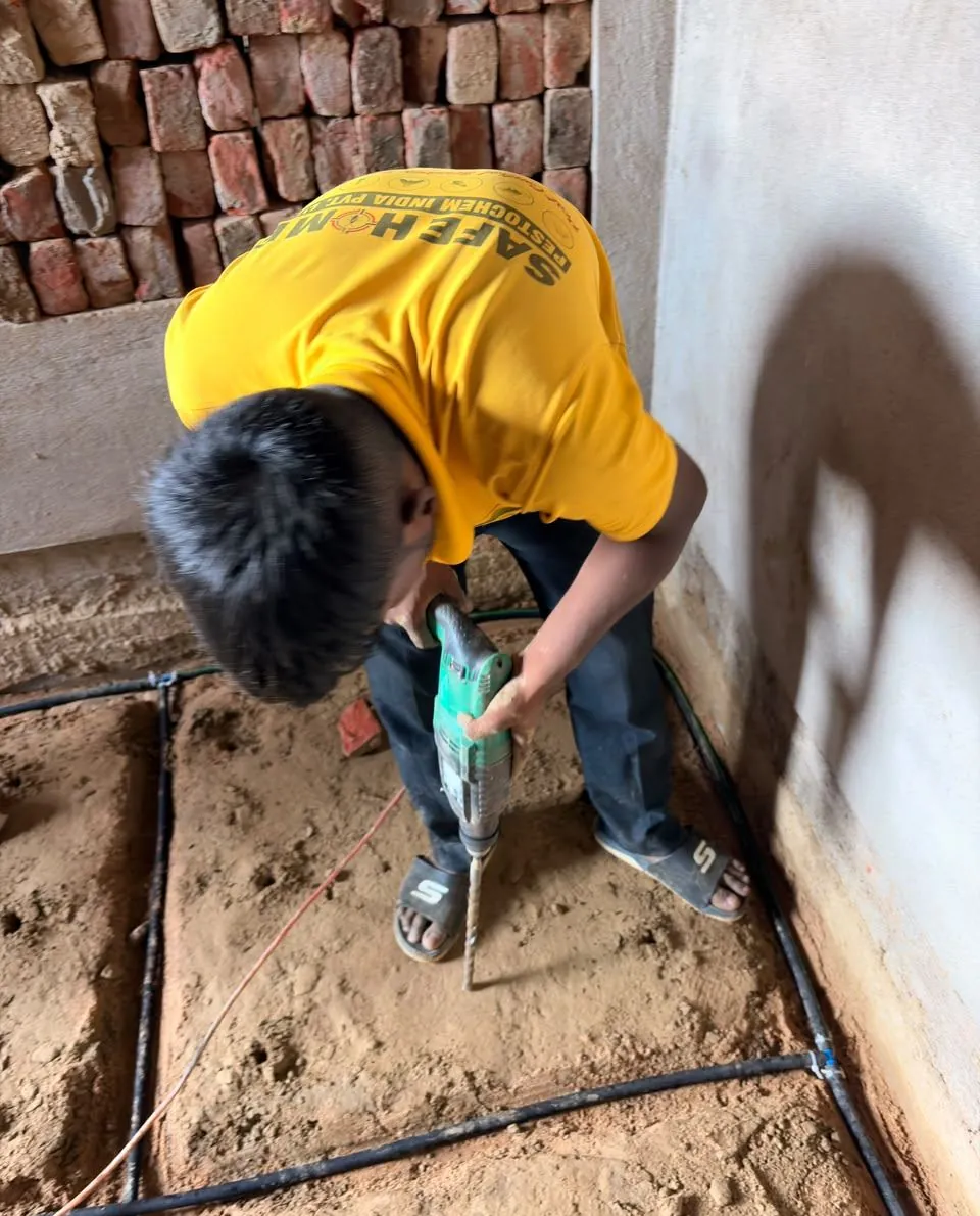 Safe Home technician laying a porous-pipe termite reticulation system in a foundation trench